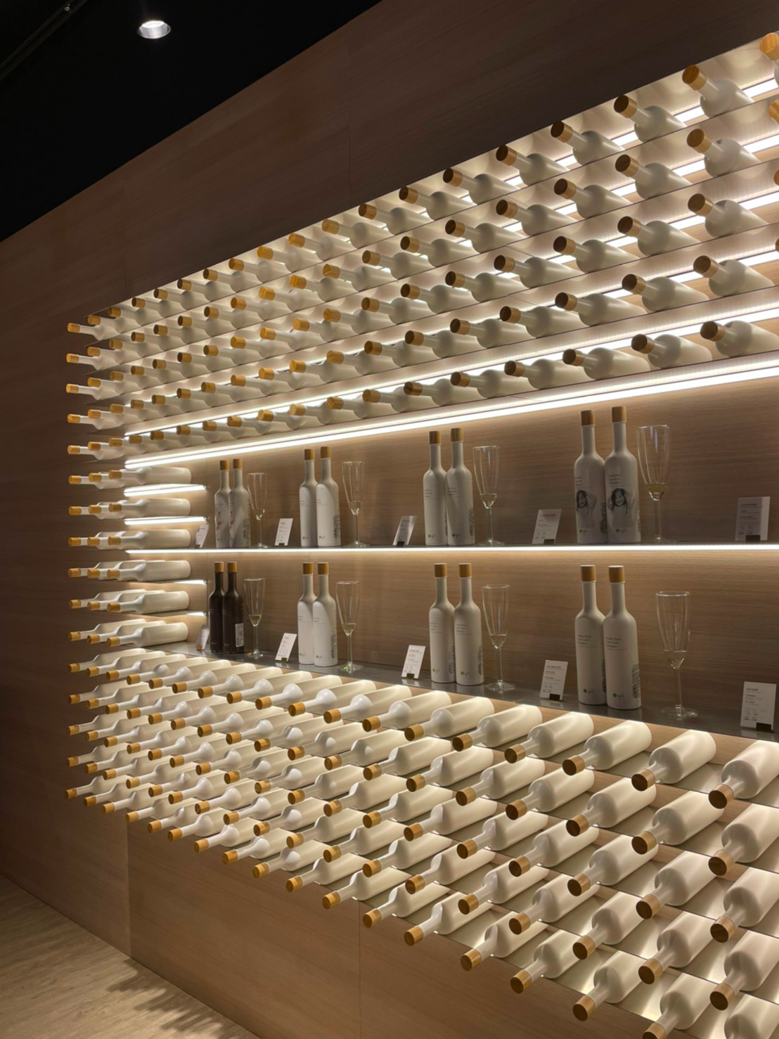 Wall of recycled white PCR bottles with bamboo caps